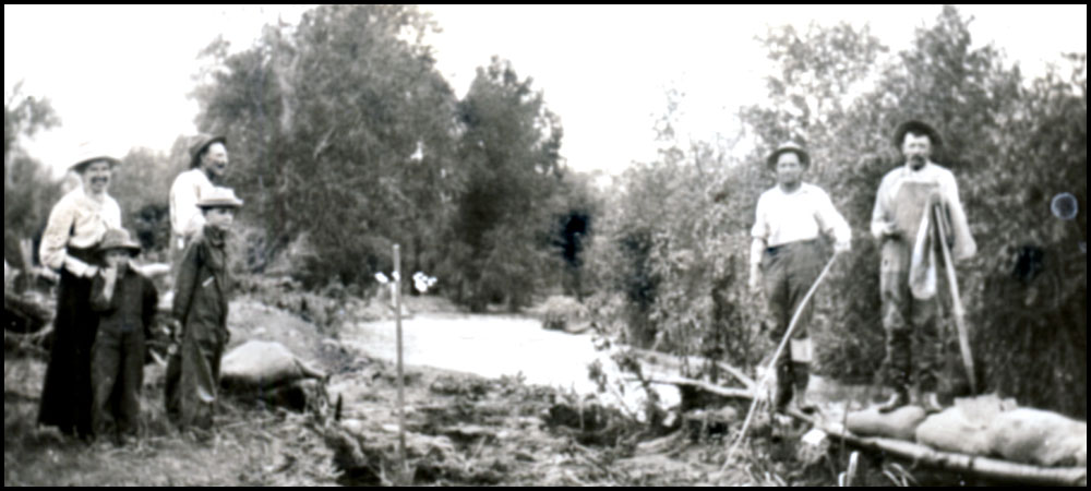 Photo taken around 1900 showing six people working on the inlet ditch to Highland Lake. There is one woman and two boys including in the photos.